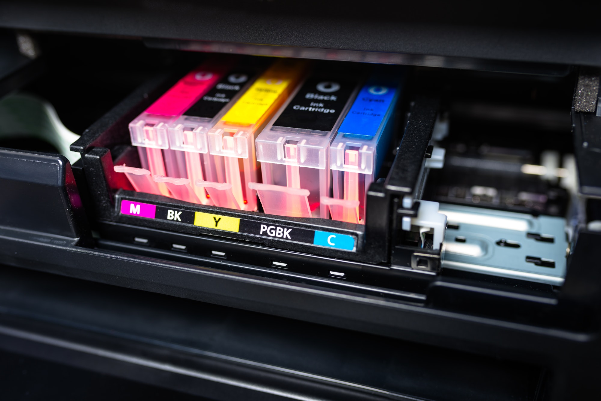 Close-up shot of a CMYK ink cartridges in a color printer