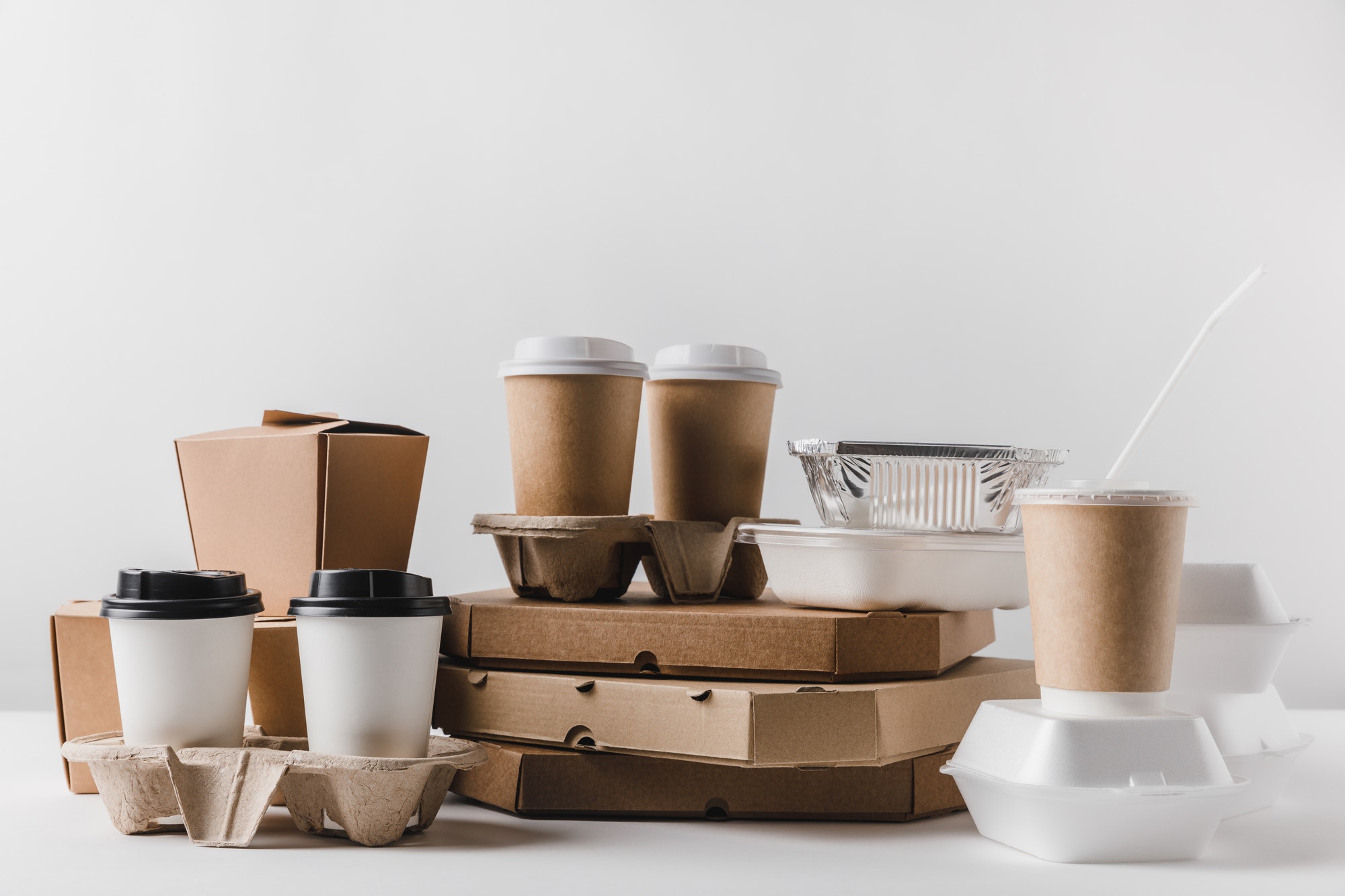 pizza boxes and coffee in paper cups with wok boxes on tabletop